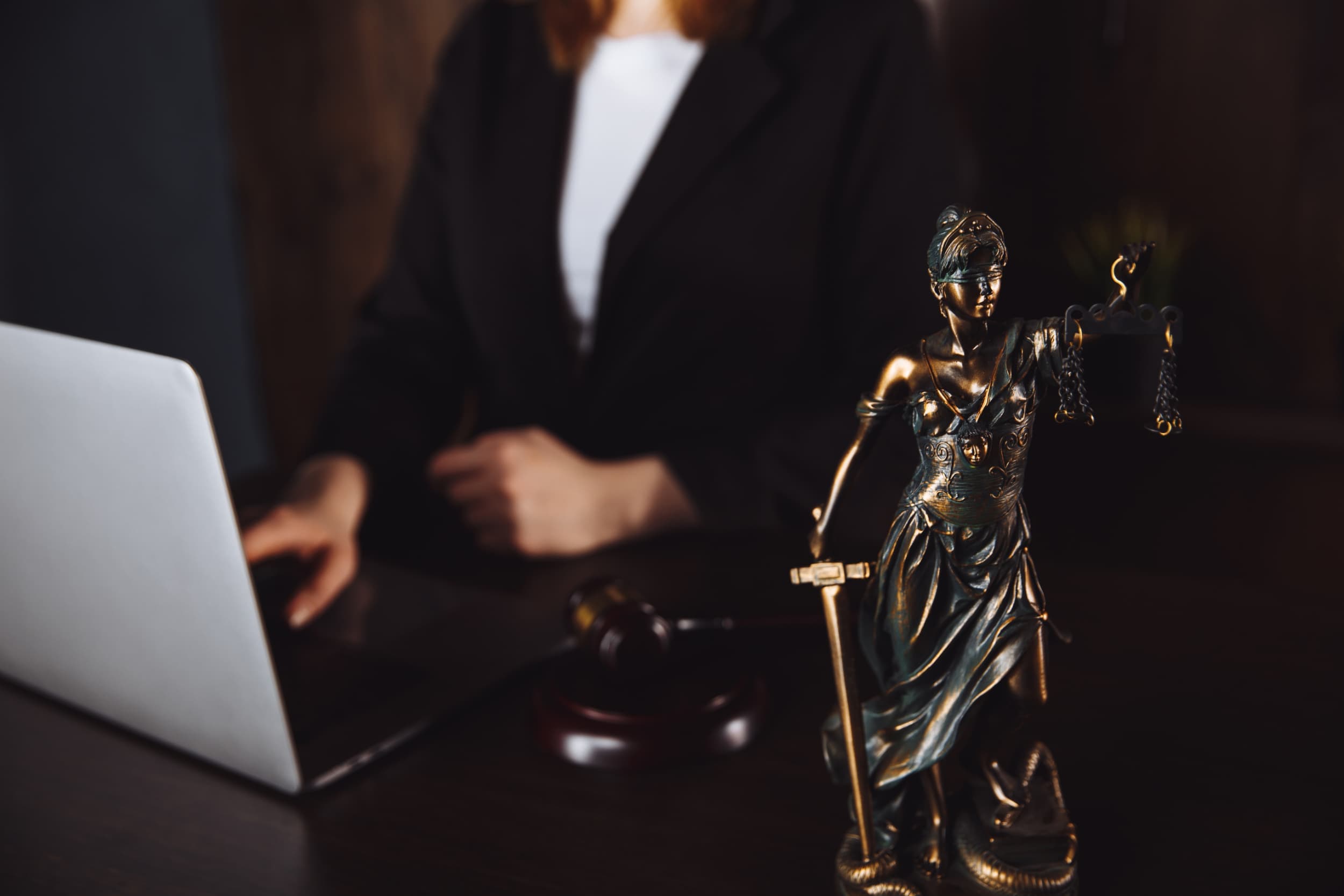 Attorney at desk with Lady Justice statue